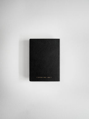 A black textured leather notebook or journal with gold foil lettering that reads 'STERLING LAW' at the bottom, centered on a light gray background.
#Color_Onyx