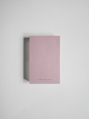 A minimalist pink notebook with 'STERLING INKY' printed in small black letters at the bottom, shown standing upright against a neutral light gray background.
#Color_Fairyfloss
