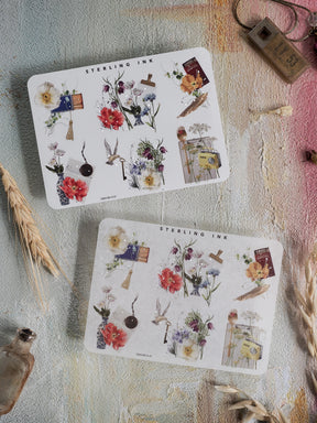 A collection of white sticker sheets featuring pastel botanical designs, adorned with watercolor flowers, delicate foliage, and decorative corner embellishments.
