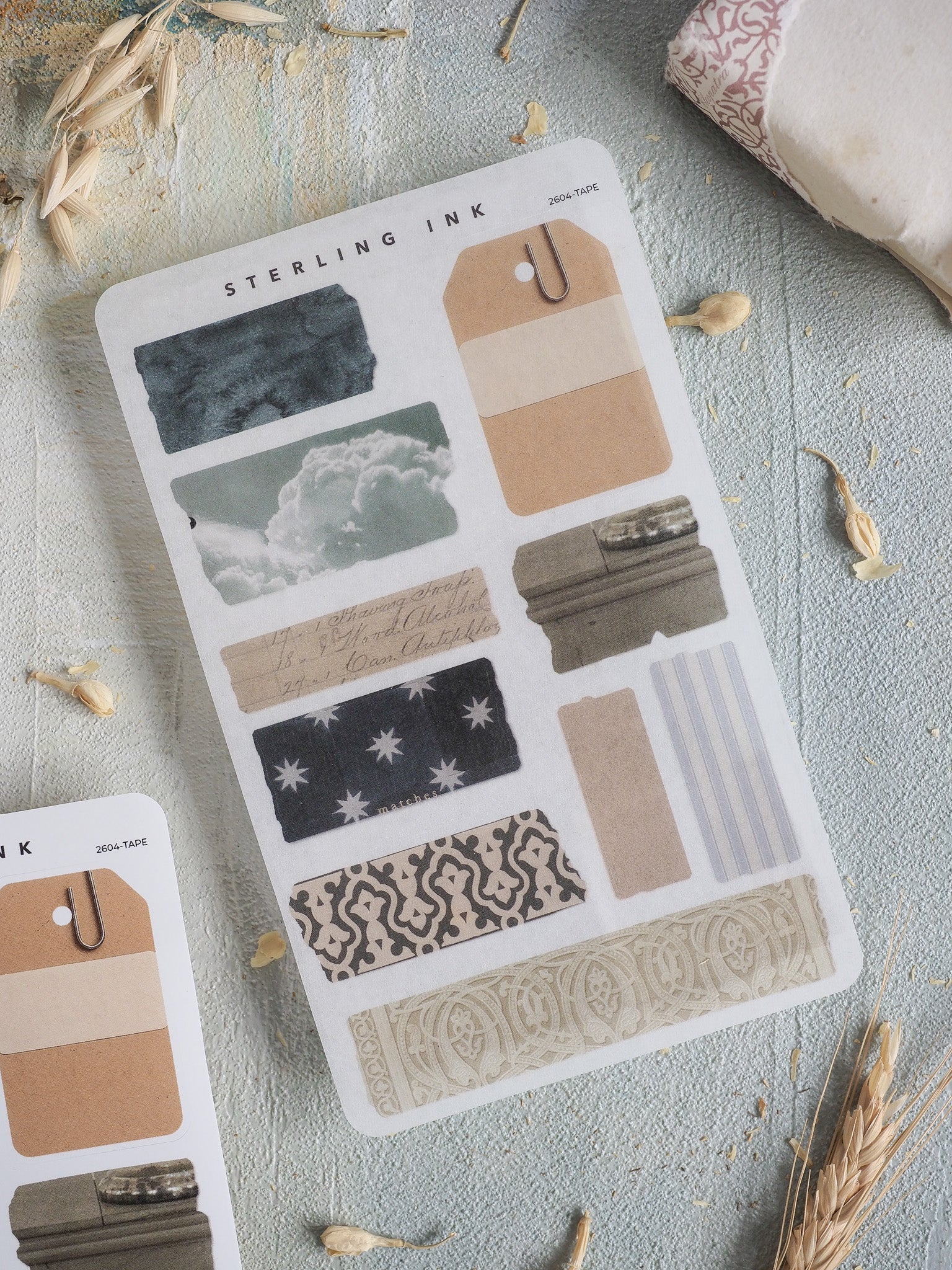 Diverse journaling sticker sheet featuring various torn tape patterns, including starry nights, floral motifs, cloudscapes, and neutral striped washi tapes.