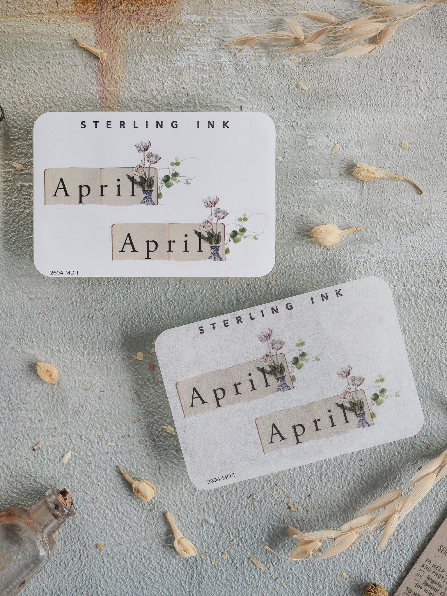 Botanical April month planner stickers featuring the text "April" and "Sterling Ink," adorned with delicate watercolor greenery and spring florals.