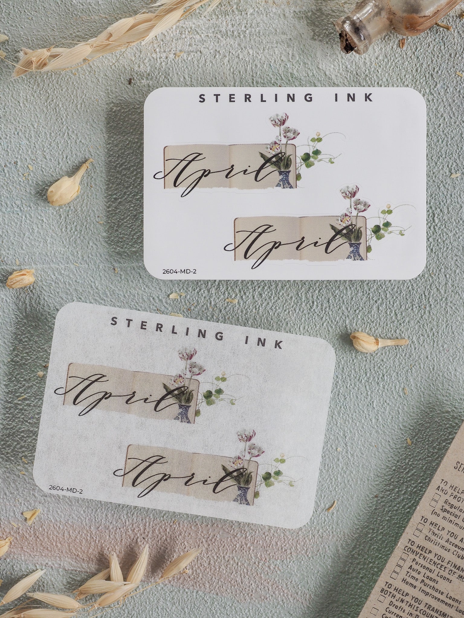 Cream-colored April sticker featuring delicate botanical floral wreaths and the elegant "STERLING INK" branding for seasonal planning.