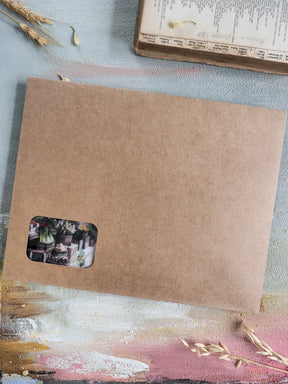 Natural brown kraft paper stationery featuring a small, decorative sticker with muted botanical illustrations, perfect for seasonal subscription kit organization.