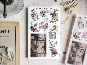 Vintage botanical sticker sheet featuring detailed natural arrangements of delicate butterflies, lilies, and various flora in muted, earthy watercolor tones.