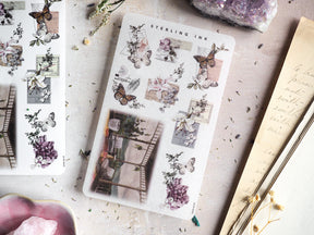 Vintage journaling stickers featuring delicate illustrated butterflies, muted lilac florals, and sepia-toned archival elements like sketch postcards.