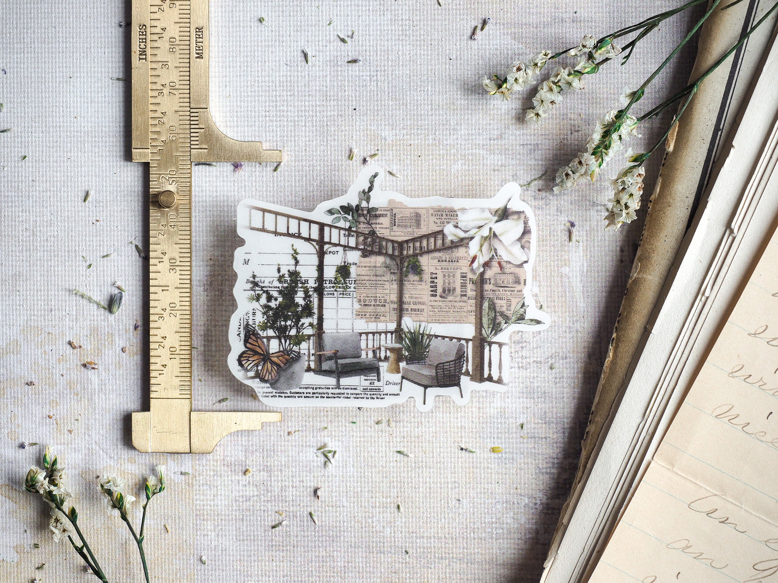 Vintage die-cut sticker set for April 2024, featuring an intricate collage of sepia-toned ephemera, architectural sketches, and detailed butterfly motifs.
