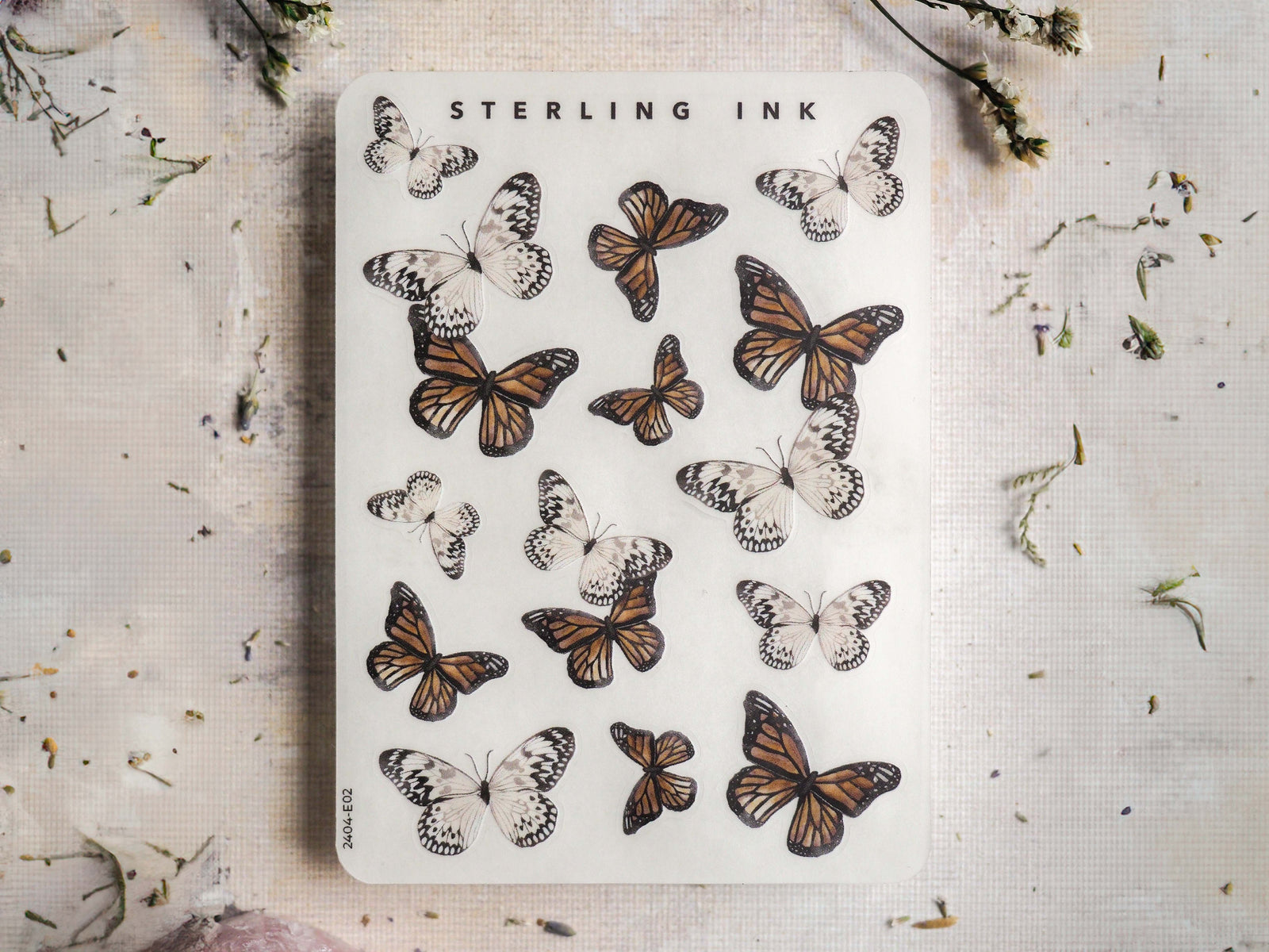 A decorative sticker sheet by Sterling Ink featuring an assortment of intricately drawn brown, black, and patterned butterflies for crafting and journaling.