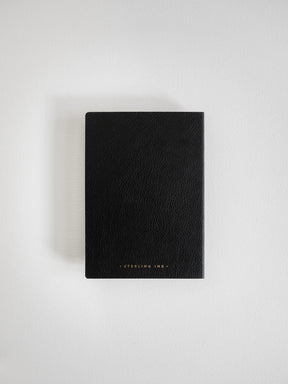 A black textured leather notebook or journal with 'STERLING INK.' printed in small gold lettering at the bottom, displayed on a clean white background.
#Color_Onyx