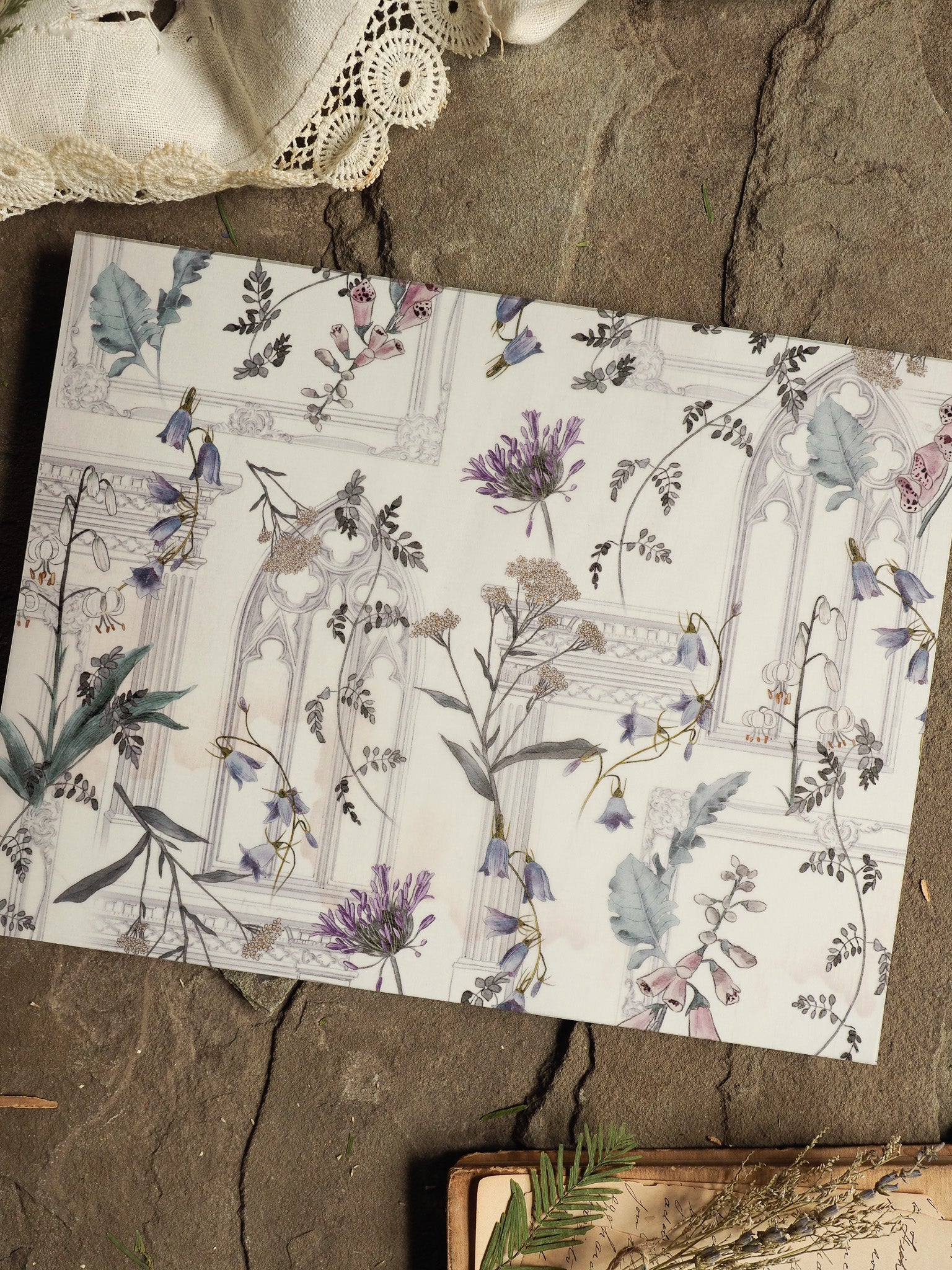 Elegant botanical sheet featuring soft watercolor lilacs and greenery within delicate architectural frames, perfect for May 2025 planning.