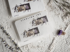 Elegant May month sticker featuring black script typography surrounded by delicate botanical and watercolor floral clusters.