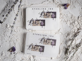Decorative May month sticker sheet displaying watercolor florals, purple and pink blooms, and "Sterling Ink" lettering.