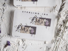 Elegant May month sticker featuring a sophisticated design of watercolor purple florals and delicate botanical elements surrounding the month's name.