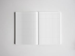Open journal displaying two white pages printed with a light gray graph paper grid, ideal for planning, drafting, or note-taking.