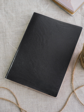 Elegant, solid black rectangular cover with a smooth matte finish, displayed within a clear protective sleeve.