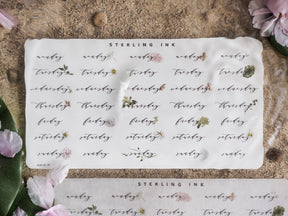Planner sticker sheet for June 2024 featuring elegant script of the days of the week accented with delicate floral illustrations.