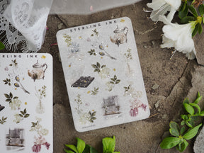 Intricate sticker sheet featuring delicate silver foil botanical icons, including vintage teapots, leaves, jars, and floral elements.