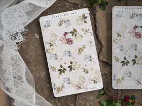 Scrapbook stickers featuring a soft, romantic botanical pattern of pale blue, blush pink, and cream flowers surrounded by fresh green foliage.