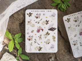 Delicate sticker sheet featuring miniature watercolor icons of botanical elements, vintage teapots, dried flowers, and ink accents for journaling and crafts.