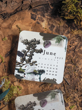 Botanical monthly calendar for June 2025, featuring a decorative layout with lush illustrations of deep green foliage, flowering lavender, and silhouette trees.