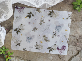 Delicate watercolor vellum featuring a romantic pattern of soft pastel florals, dusty blues, and scattered sage green leaves.