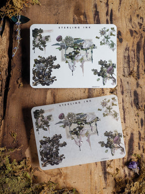 Sticker sheets with a vintage botanical pattern, featuring muted watercolor florals, dried greenery, and delicate natural corner elements for crafting.