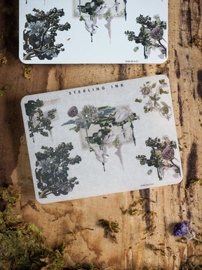 A sheet of decorative stickers featuring botanical clusters, flowing florals, and natural greenery, finished with elegant silver foil accents for edges and corners.