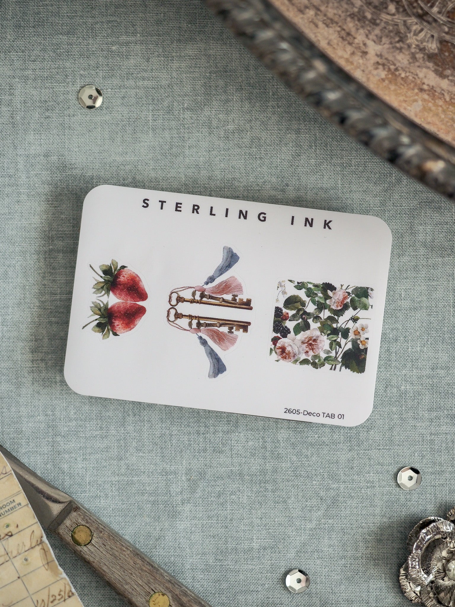 Watercolor illustration card by Sterling Ink showcasing seasonal designs of red strawberries, classical flutes, and delicate floral bouquets.