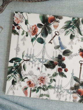 Elegant watercolor pattern illustration featuring blush roses, deep green foliage, scattered dark berries, and vintage elements like candelabras, keys, and a blue bird.