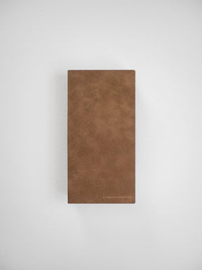 Cognac-brown faux leather journal cover with a rich, textured finish and subtle "COMMON PLANNER" branding.