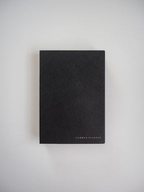 Compact, vertical black planner featuring a textured, faux-leather cover and subtly debossed "COMMON PLANNER" branding.