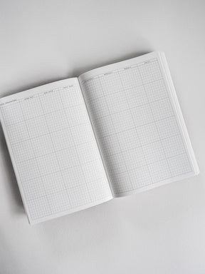 Open A5 planner displaying detailed, clean grid paper sections for highly organized daily, weekly, and monthly planning.