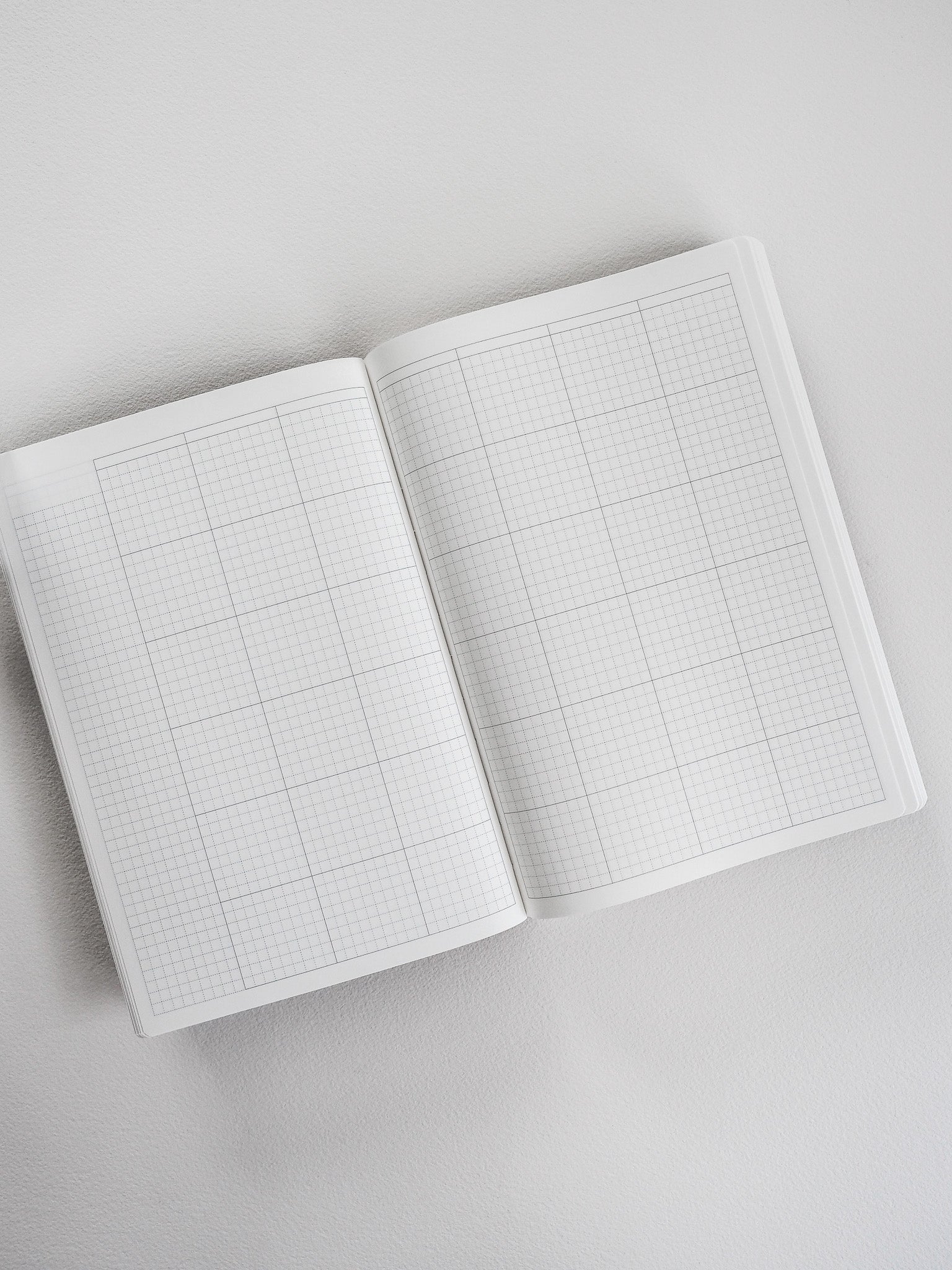 Open A5 planner showing light gray grid paper across both pages, perfect for common journaling or structured note-taking and planning.
