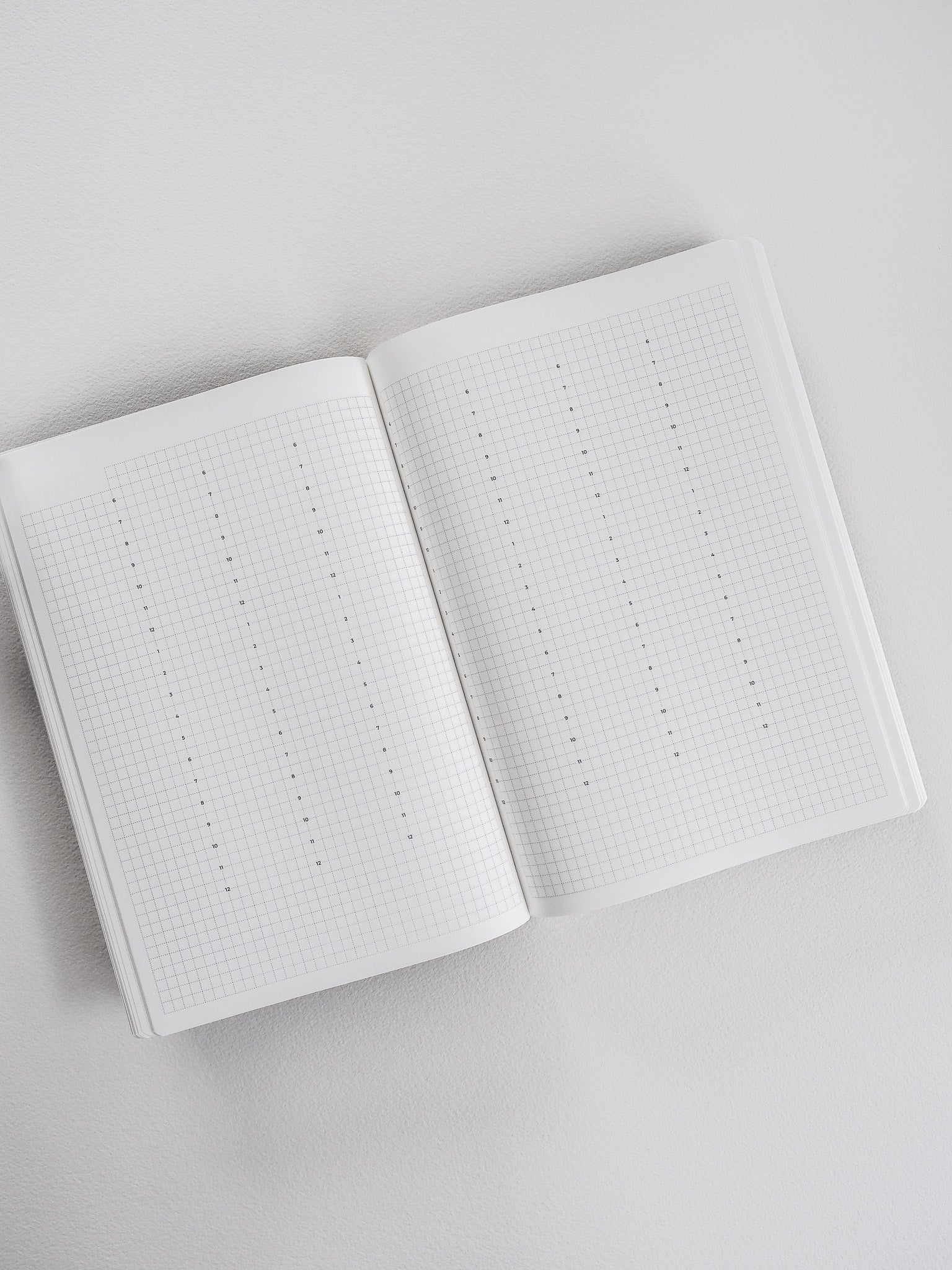 Open A5 undated planner showing white graph paper grids and ruled pages perfect for comprehensive yearly note-taking and flexible planning.