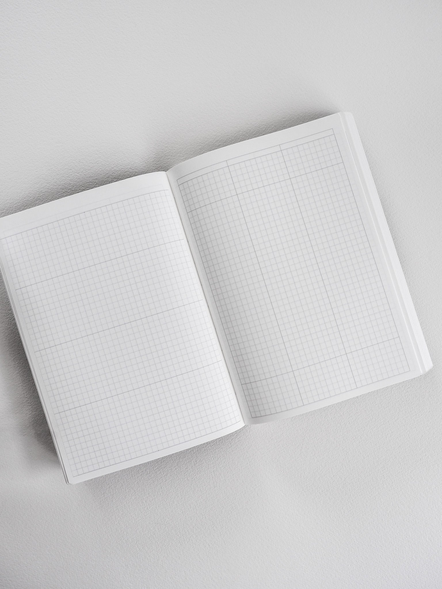 Open B6 common planner featuring crisp, white graph paper grids across both facing pages, ideal for detailed note-taking and functional planning.
