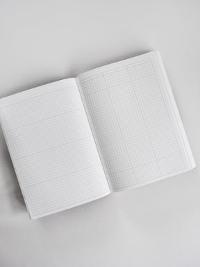 Open B6 common planner featuring crisp, white graph paper grids across both facing pages, ideal for detailed note-taking and functional planning.