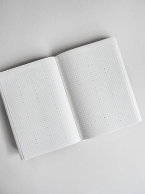Open planner book displaying dot grid paper suitable for journaling, bullet journaling, or creating a comprehensive undated schedule.