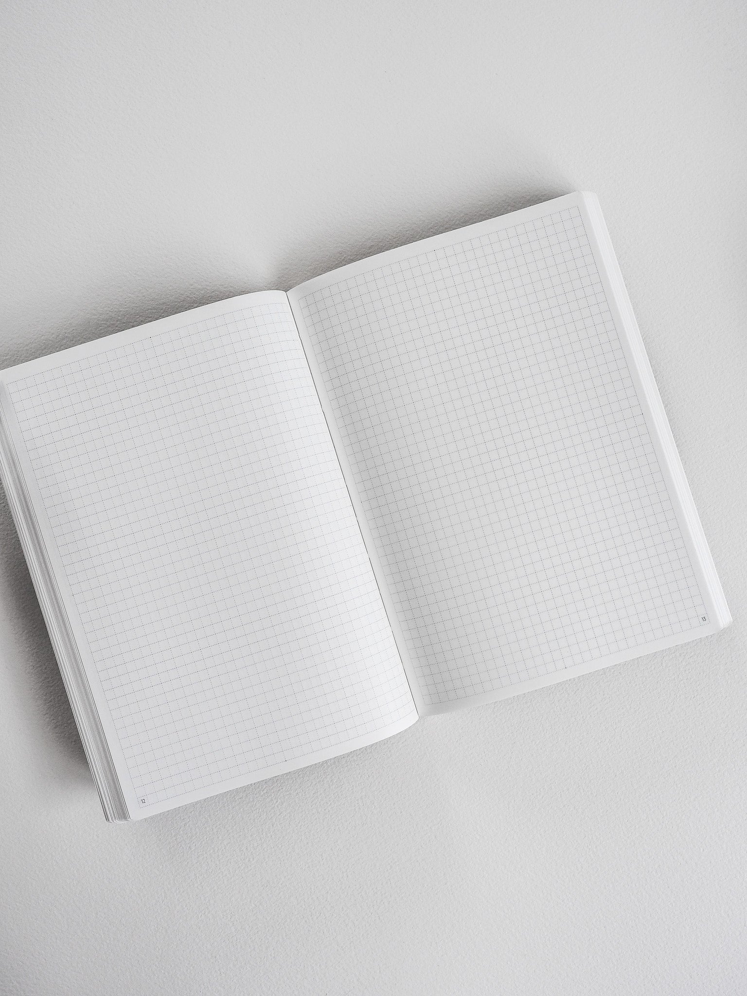 Open B6 undated planner displaying two pages with faint, light-gray graph paper grids, perfect for structured note-taking and common planning.