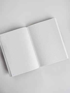 Open B6 undated planner displaying two pages with faint, light-gray graph paper grids, perfect for structured note-taking and common planning.