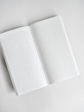 Open planner book showing two pages of crisp white, perfectly gridded graph paper, ideal for common planning, sketching, and note-taking.