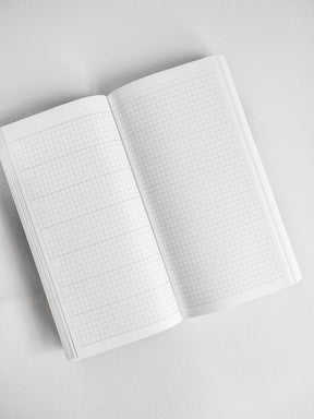 Open undated common planner showing crisp white graph paper grids perfect for customizable note-taking and journaling.