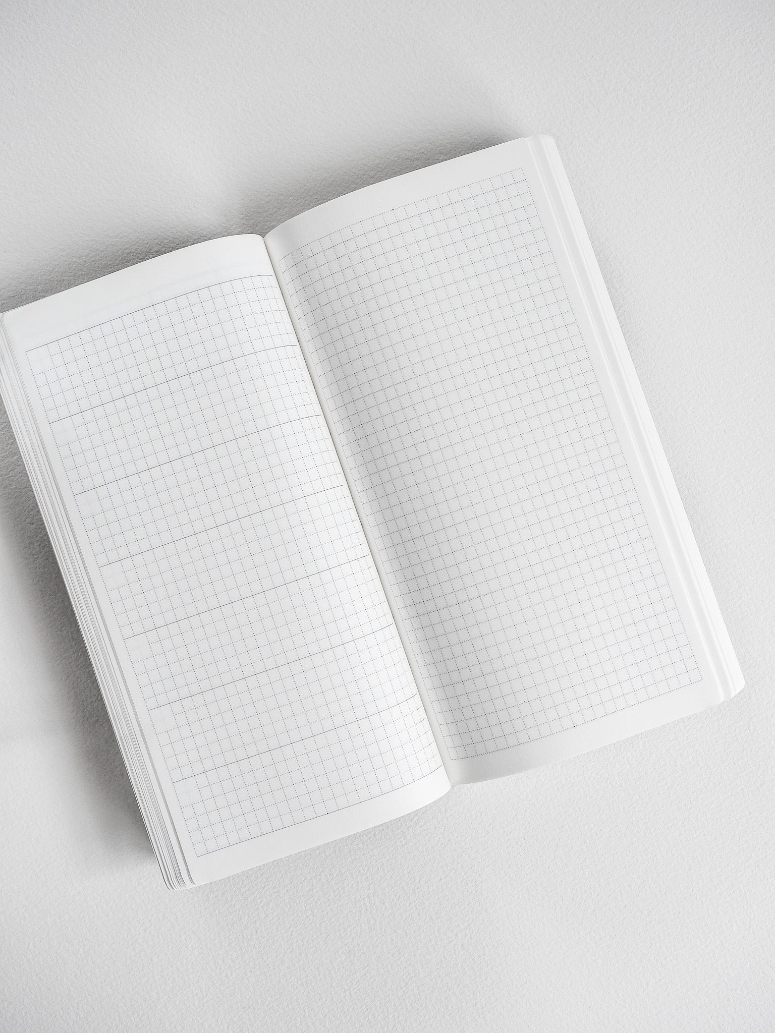 Open graph planner featuring light gray grid lines across clean white pages, perfect for detailed undated note-taking and flexible scheduling.