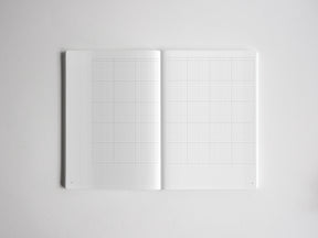 Open sketchbook featuring dual pages of light gray graph paper, perfect for structured note-taking, drawing, graphing, or detailed academic planning.