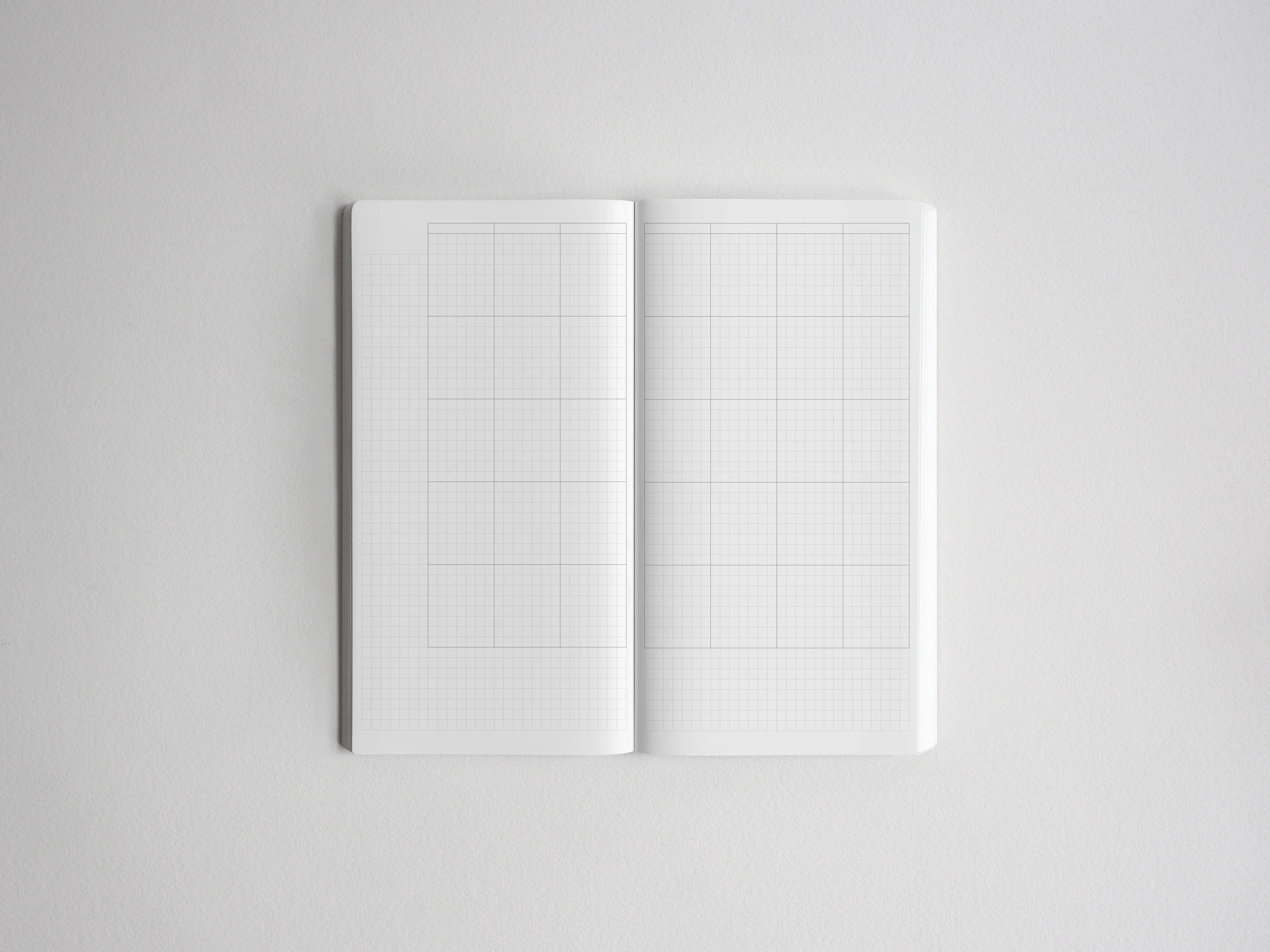 Open spiral planner notebook displaying a crisp, light gray graph paper grid, ideal for technical drawing, detailed note-taking, or bullet journaling.