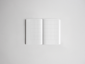 Open notebook featuring two pages of light gray graph paper grids, perfect for drawing, charting, or structured note-taking.