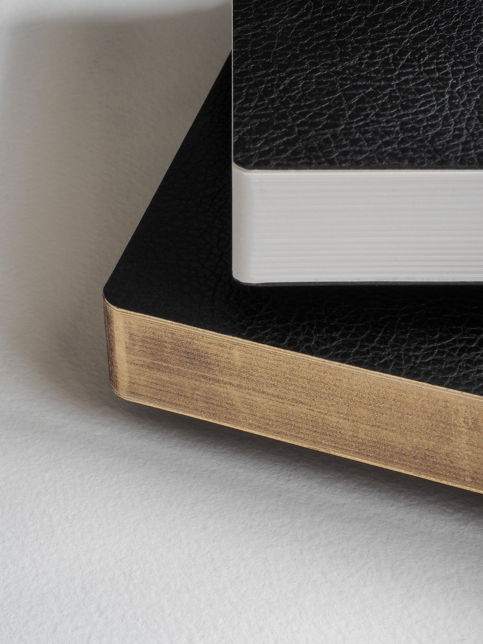 Stacked set of sophisticated black pocket notebooks featuring a subtle, textured faux leather cover and lined pages for writing.