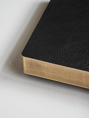 Black, textured pocket notebook bound with contrasting natural wood-toned edges, featuring 520 lined pages for journaling.