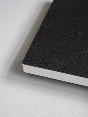 Rich black A5 notebook featuring a textured, faux-leather cover and crisp white pages, ready for writing 272 lined pages of notes or journaling.