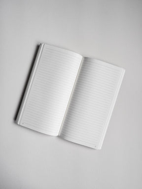 Open notebook displaying crisp white, ruled pages with visible sequential page numbers, ideal for notes and journaling.