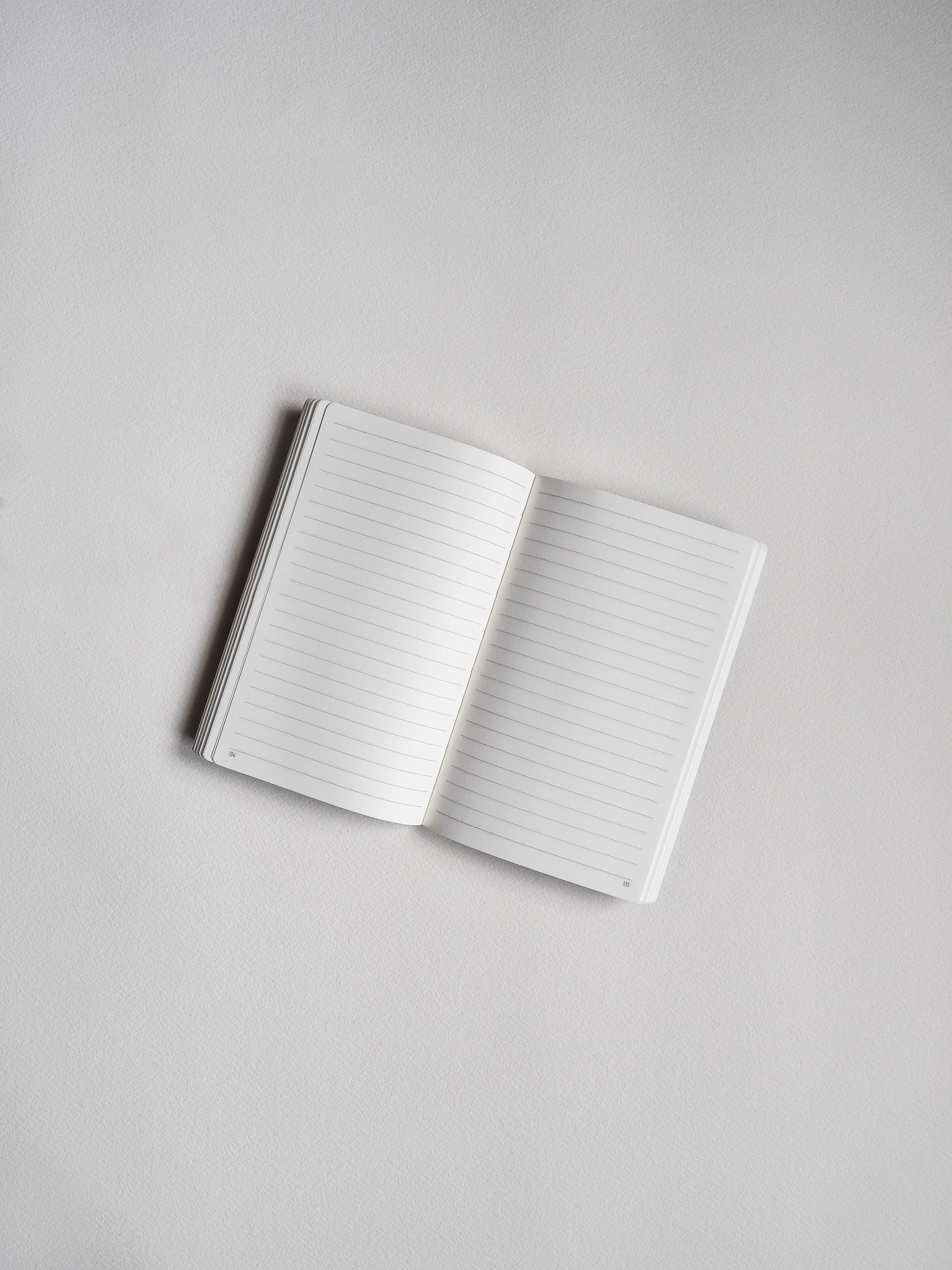 Open pocket journal featuring pristine lined pages and visible page numbering, perfect for organized and dedicated note-taking.