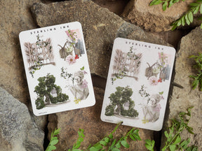 Two large icon stickers featuring vintage watercolor illustrations of antique architecture, lush floral arrangements, and an elegant woman's portrait.